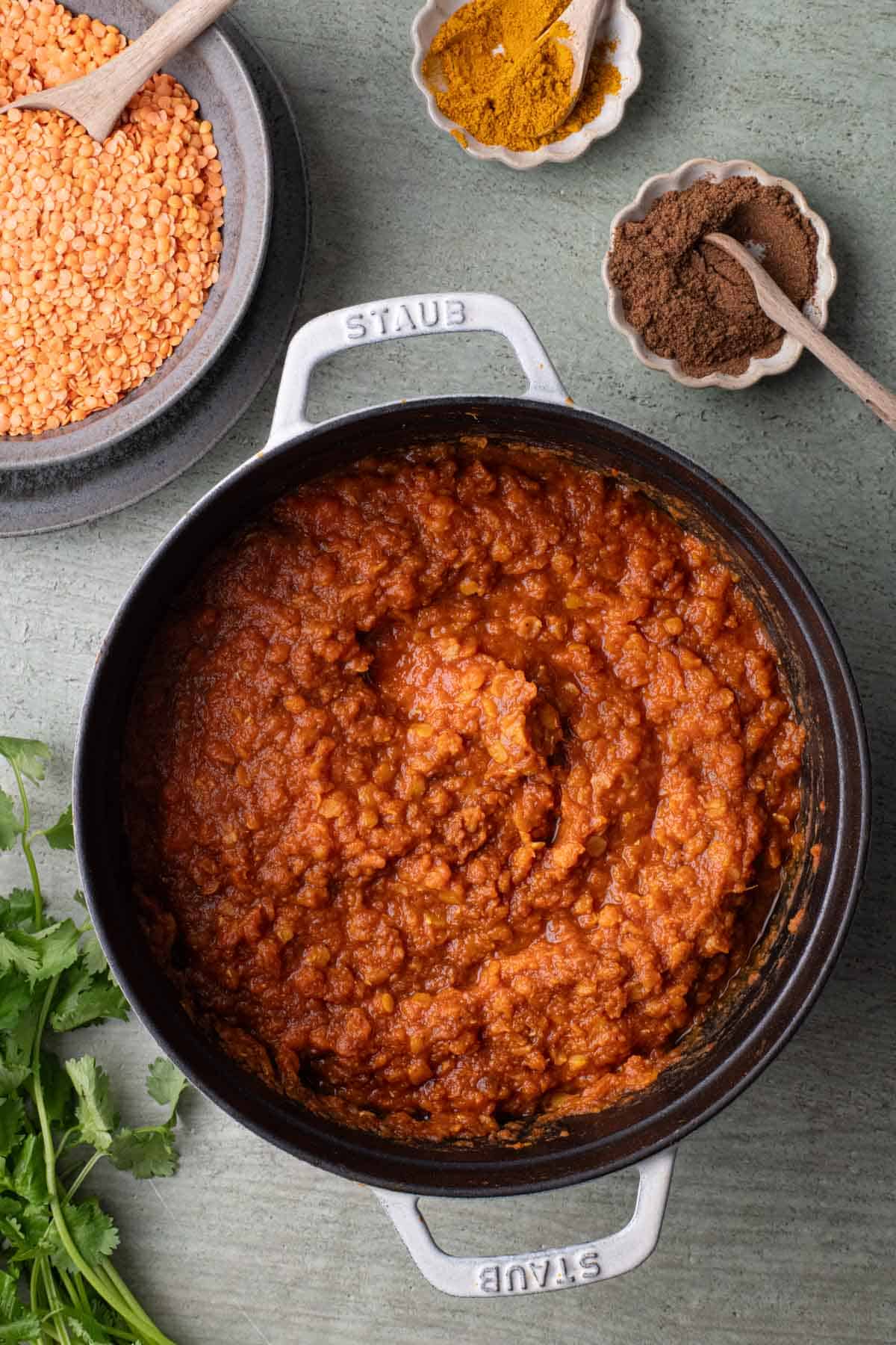 Spiced red lentil stew with ginger in a Dutch oven with red lentils, curry powder, garam masala, and cilantro