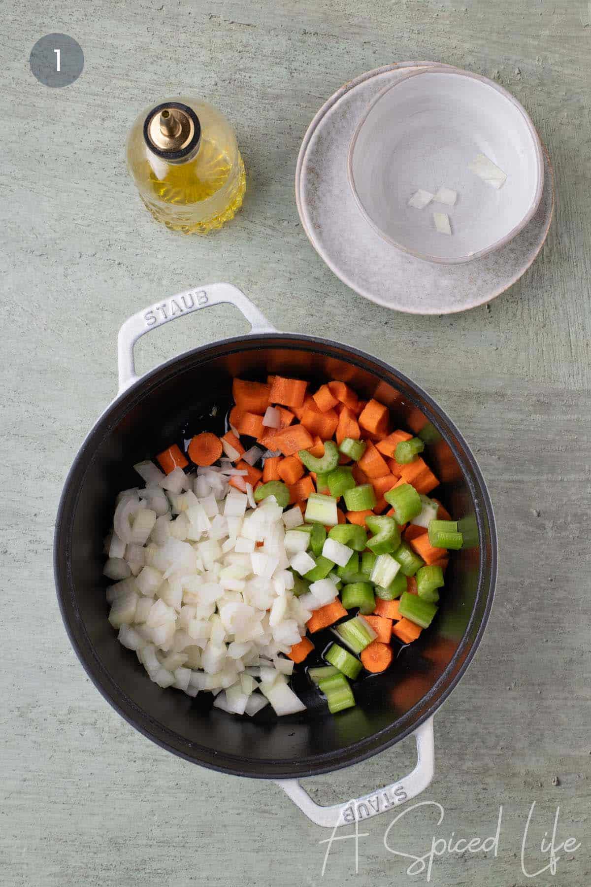 Chopped onion, carrots, and celery in a Dutch oven with olive oil for red lentil stew