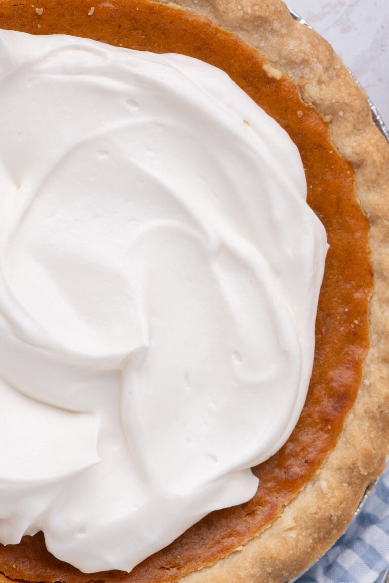 Close-up of soft whipped cream peaks on a pumpkin pie