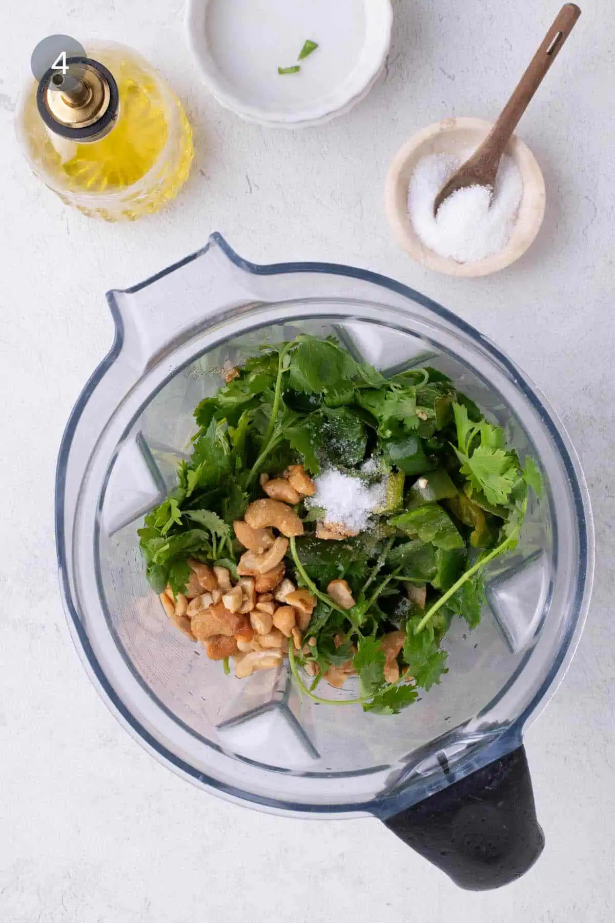 Cilantro, cashews, serrano chiles, and salt in a blender for cilantro cashew pesto.