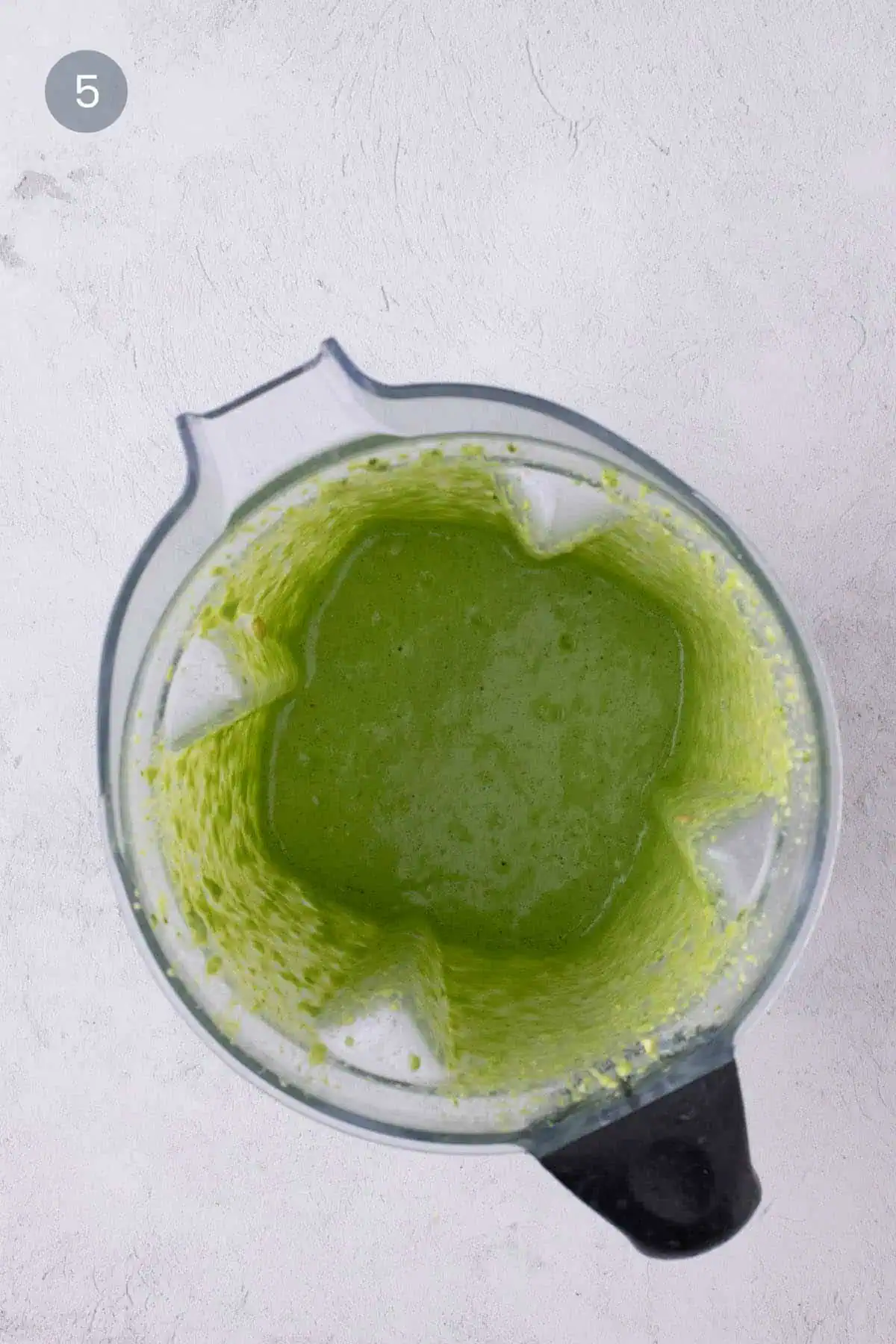 Smooth green cilantro cashew pesto blended in a blender.
