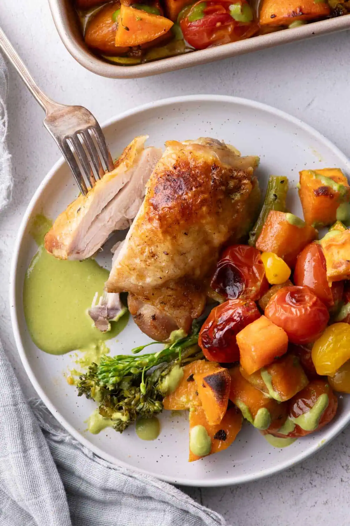 Crispy roasted chicken thigh served with caramelized sweet potatoes, broccolini, cherry tomatoes, and cilantro cashew pesto.