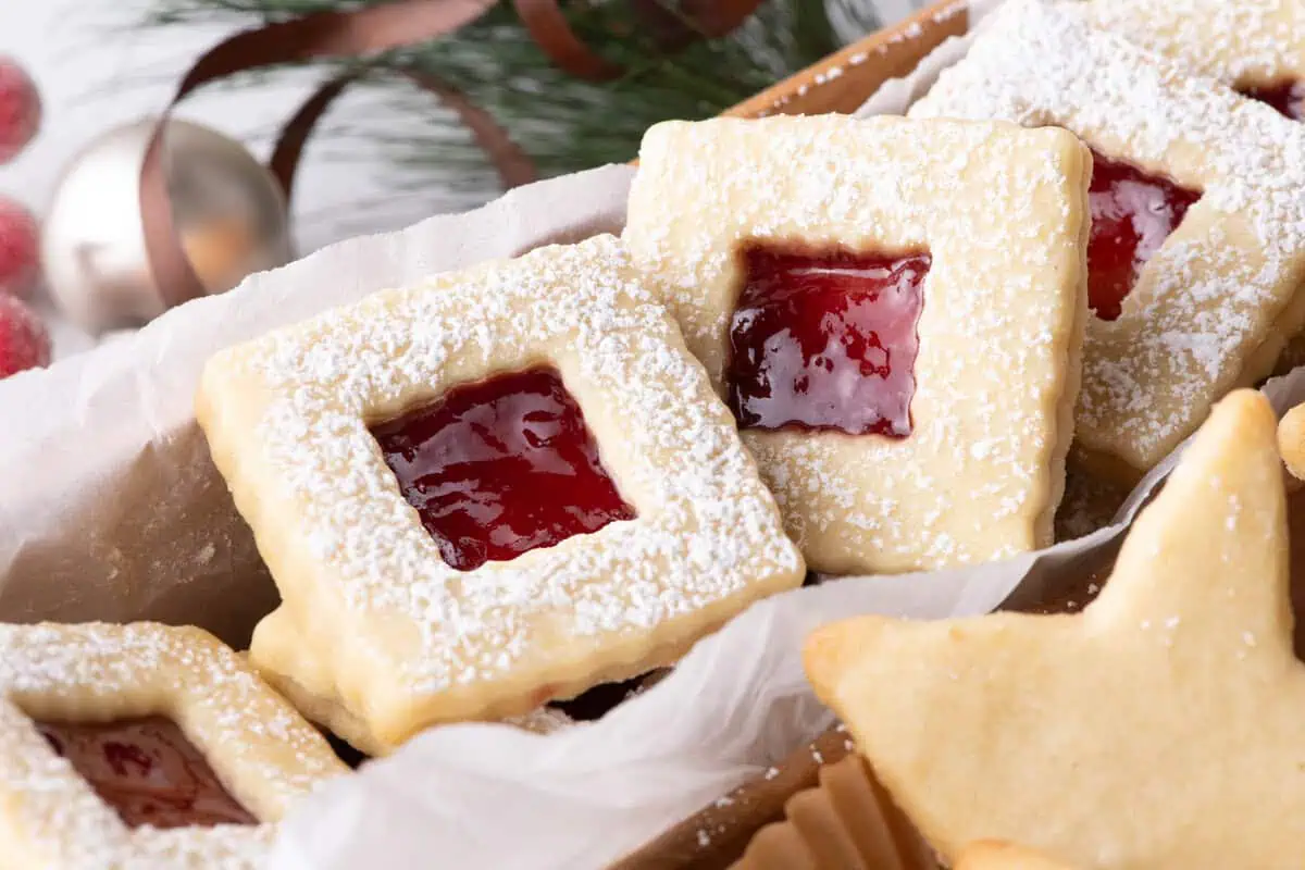Homemade holiday cookie box filled with assorted Christmas cookies in a divided wooden tray
